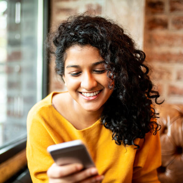 Young woman using mobile phone inside store